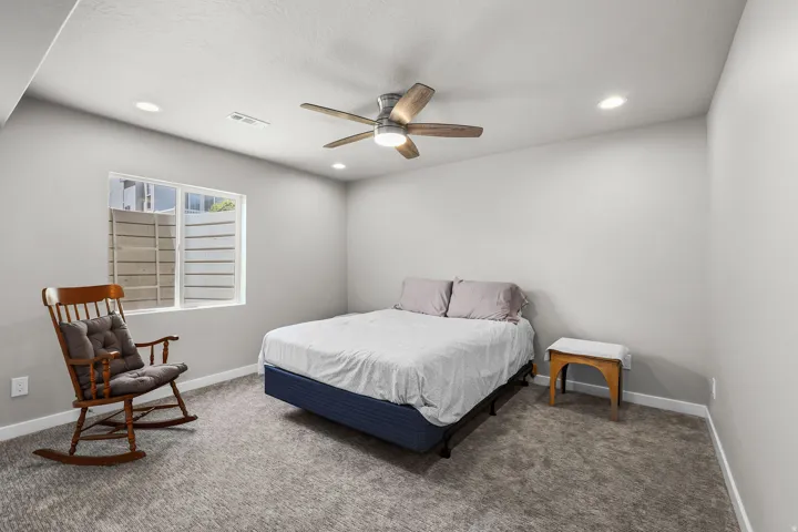 Carpeted room with a ceiling fan, recessed lighting, and a white window frame with horizontal louvered blinds