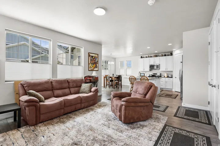 Open-concept living area with wood-finish flooring extending into the kitchen and dining areas