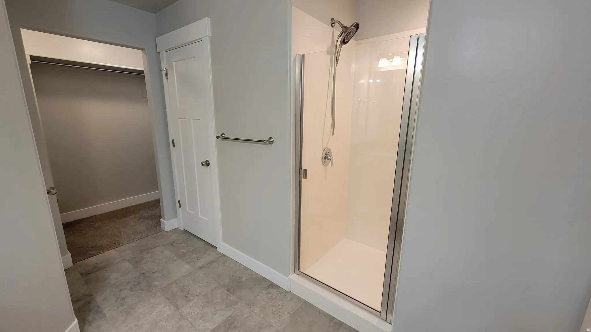 Walk-in shower with clear glass enclosure and chrome fixtures