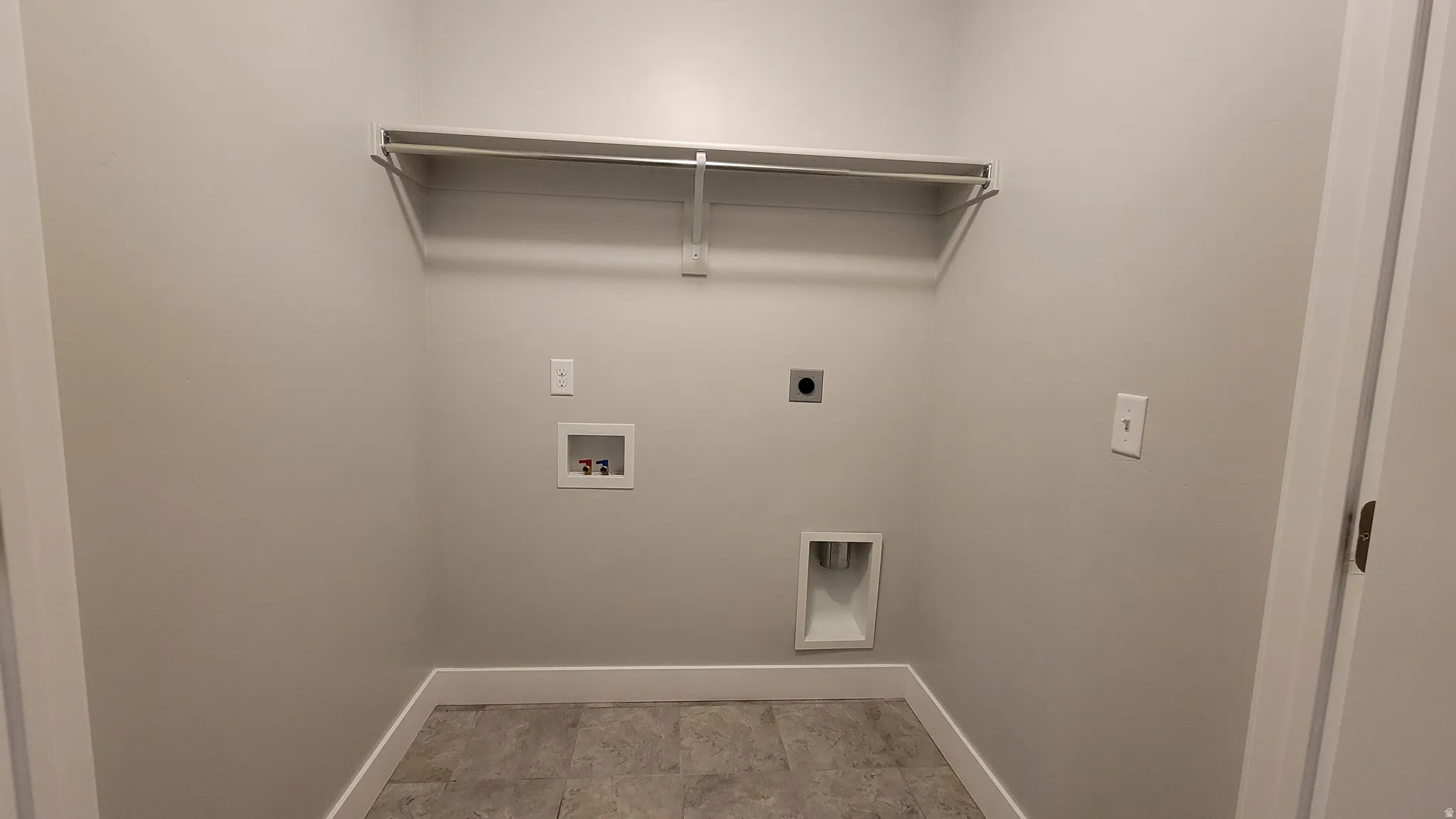 Dedicated utility space featuring a built-in wire shelf and hanging rod