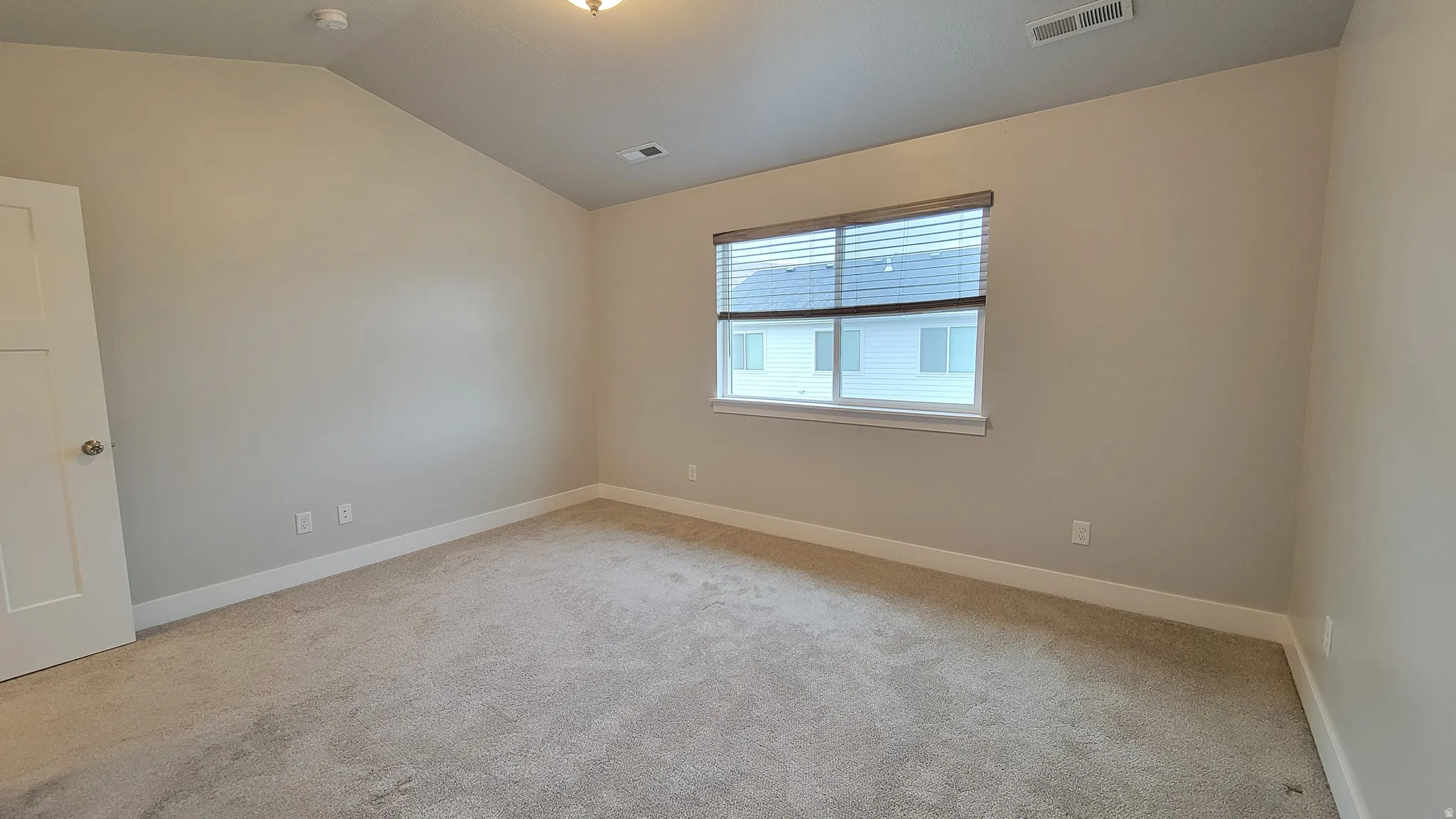 Carpeted interior room featuring light gray wall paint and white trim