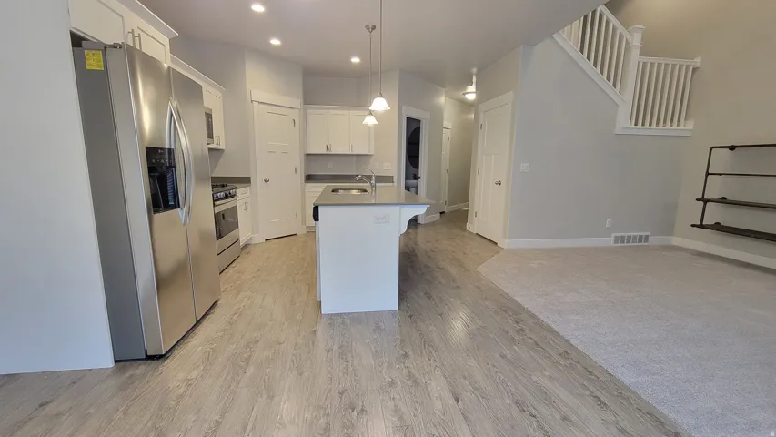 Contemporary kitchen featuring white cabinetry and stainless steel appliances