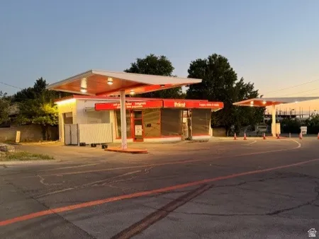 Commercial building with prominent overhead canopies, multiple entry points, and an expansive paved lot