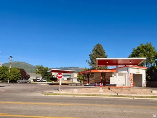Commercial property featuring an orange and white structure with a prominent canopy, drive through, and a paved lot