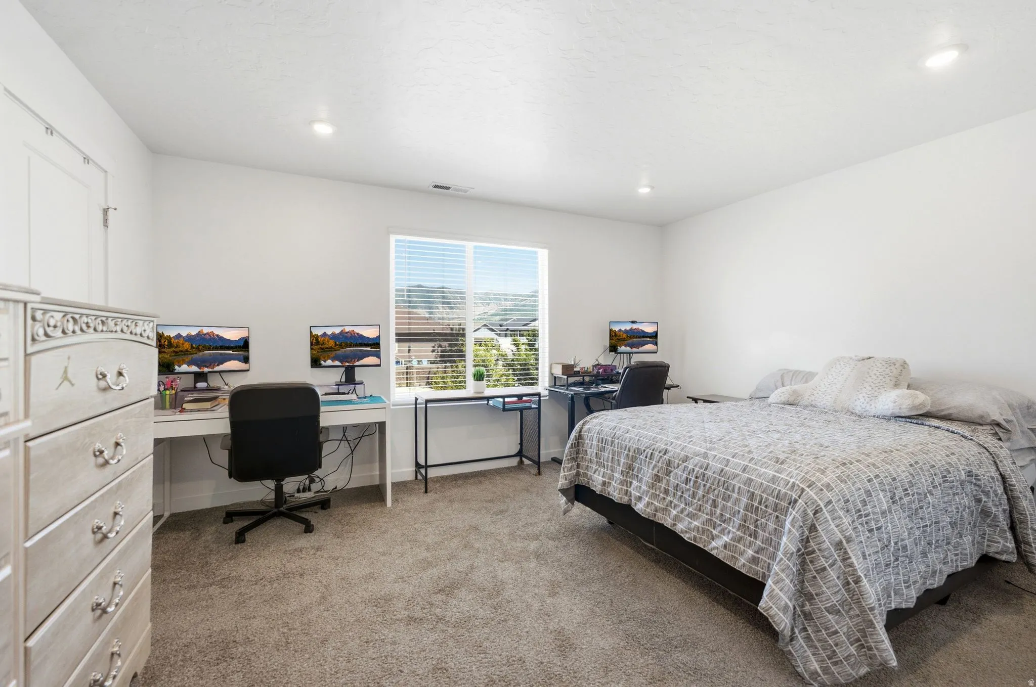 Spacious primary room featuring neutral carpeting, recessed lighting, and a large window with horizontal blinds