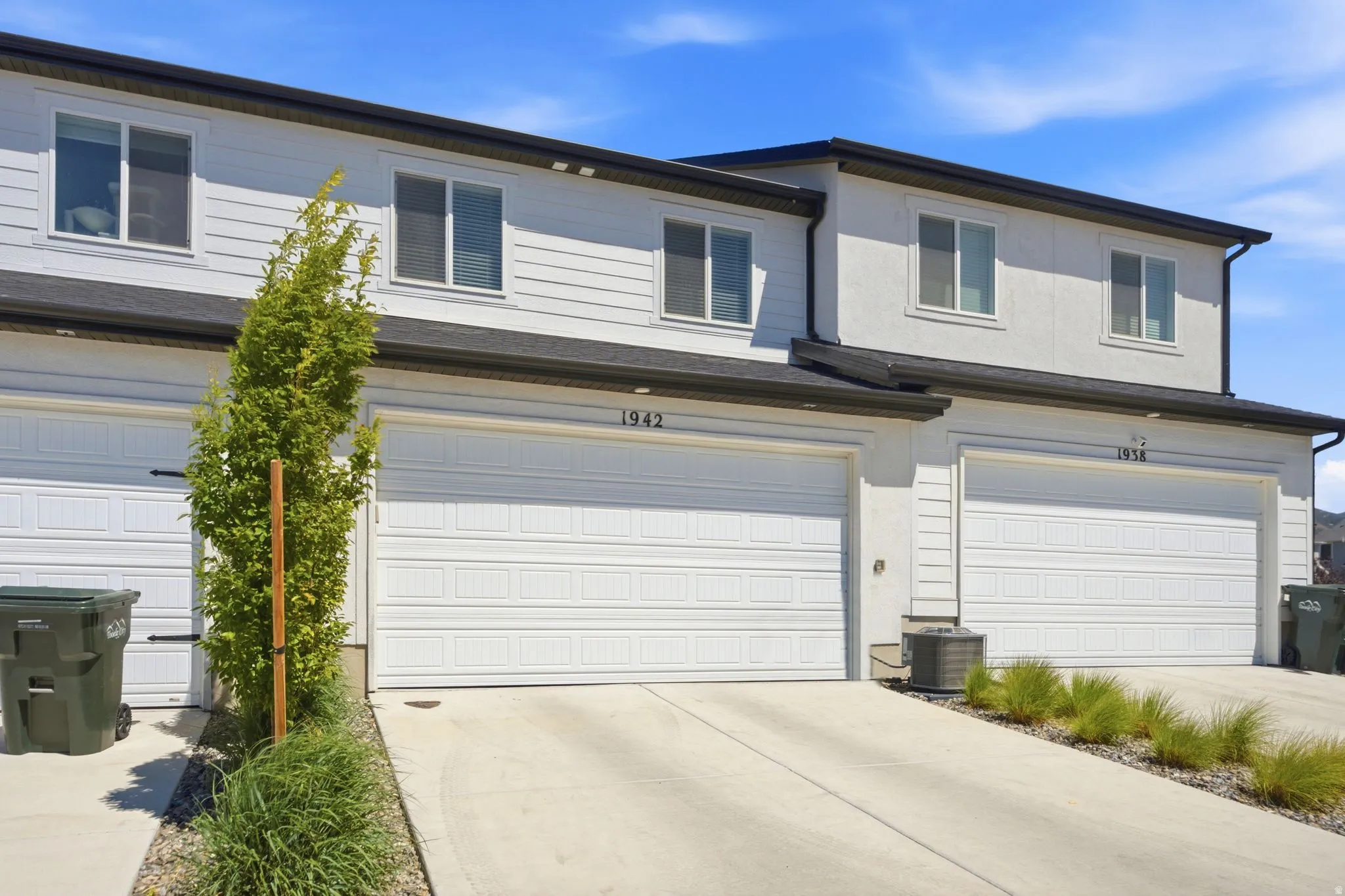 Contemporary townhome exterior featuring light-toned siding and stucco finishes