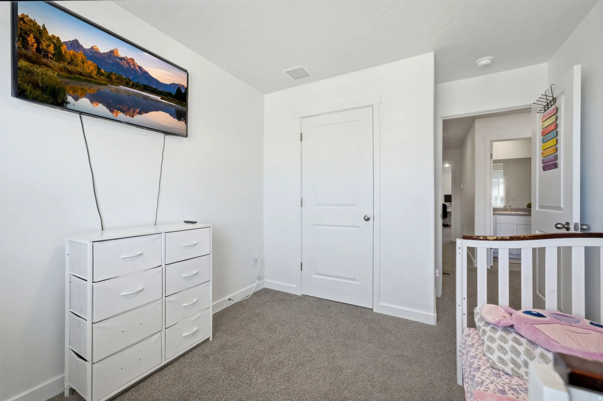 Carpeted room with a white door featuring a brushed nickel knob