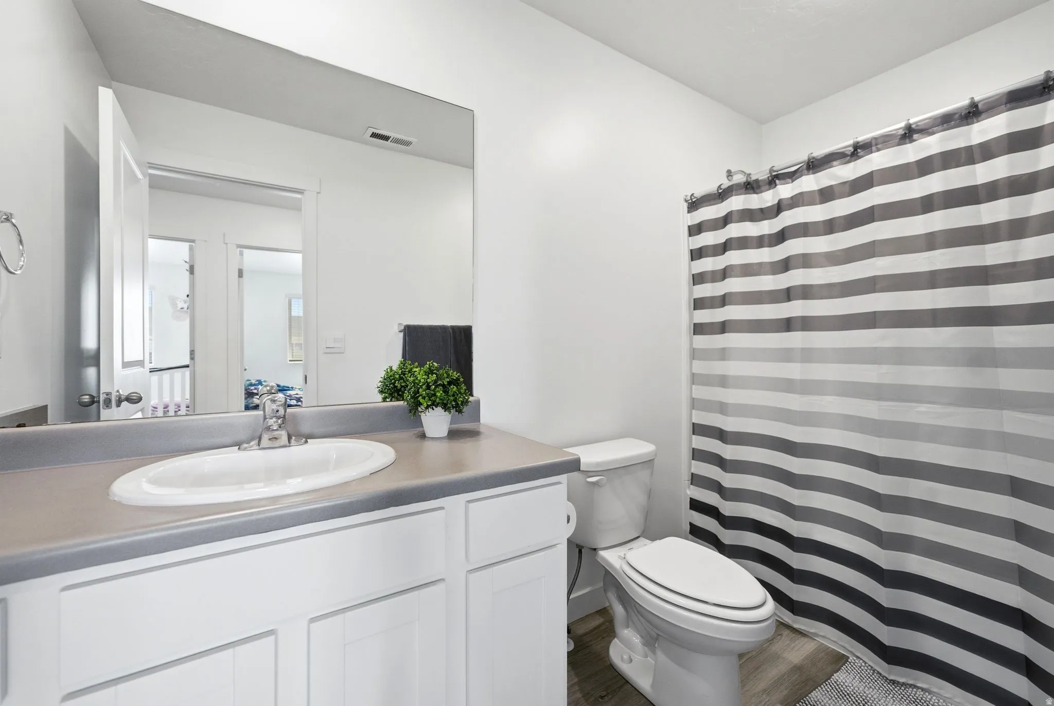 Bathroom featuring a white vanity with cabinet storage, integrated sink, and a gray countertop