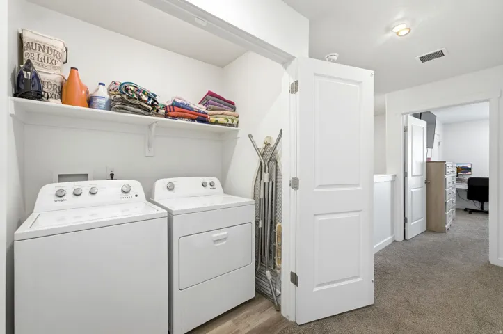 Dedicated laundry area featuring a white top-load washer and front-load dryer