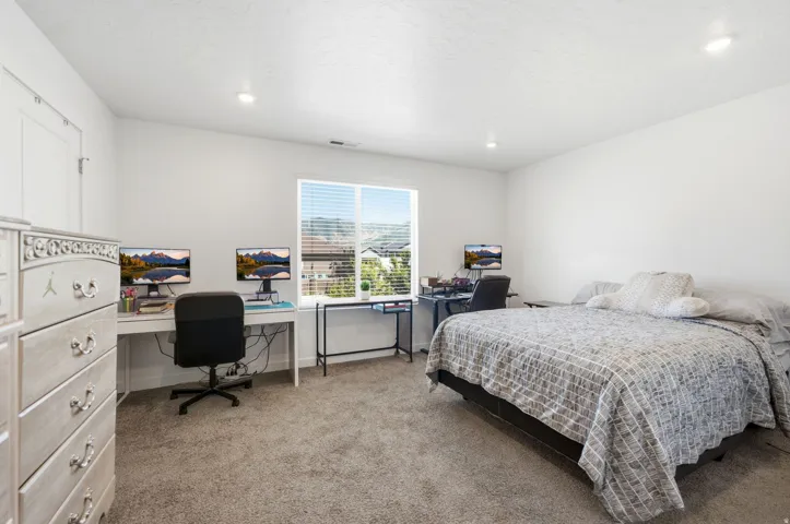 Spacious primary room featuring neutral carpeting, recessed lighting, and a large window with horizontal blinds