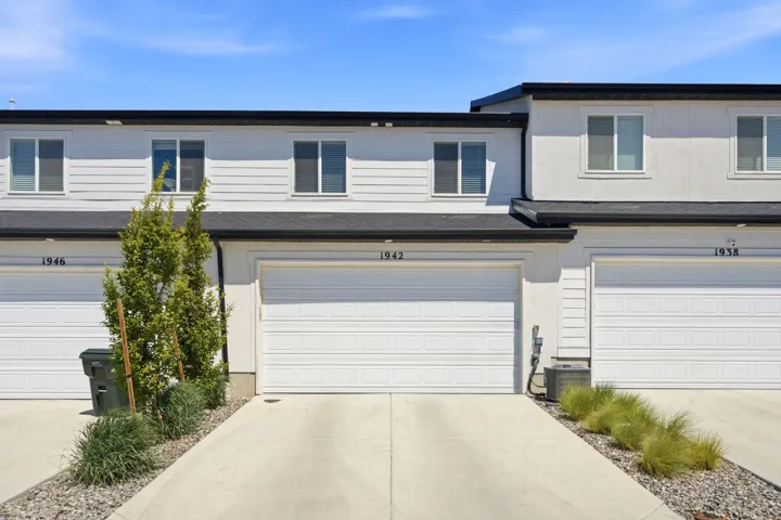Contemporary multi-unit dwelling with white siding and a black roof