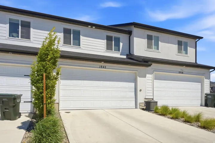 Contemporary townhome exterior featuring light-toned siding and stucco finishes