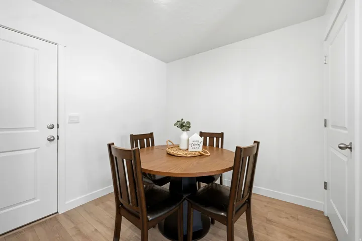 Dining area featuring wood-finish flooring, white walls, and bright overhead lighting