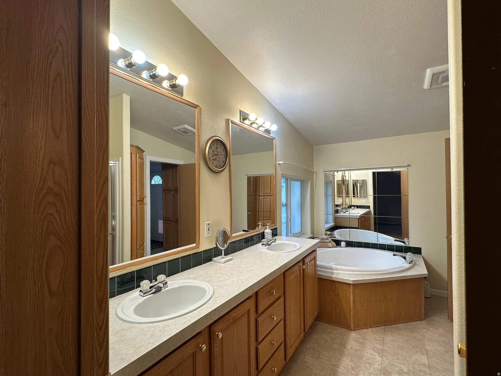 Dual vanity with wood-finish cabinetry, integrated sinks, and extended countertop