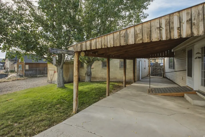 Covered concrete patio with wood-slat ceiling and support columns