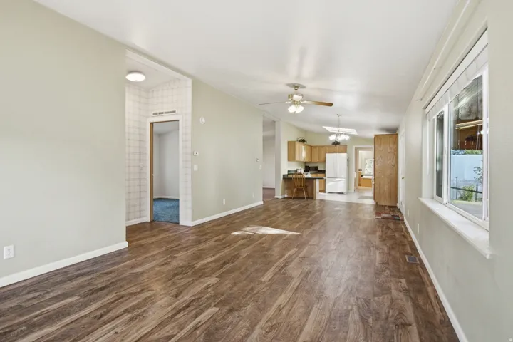 Spacious interior featuring wood-finish flooring, light-toned walls, and a large window providing natural illumination