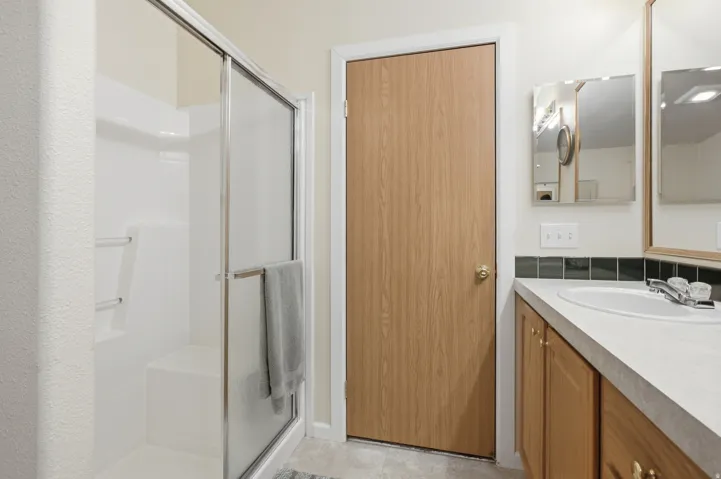 Bathroom featuring a separate shower with a sliding glass door and built-in bench