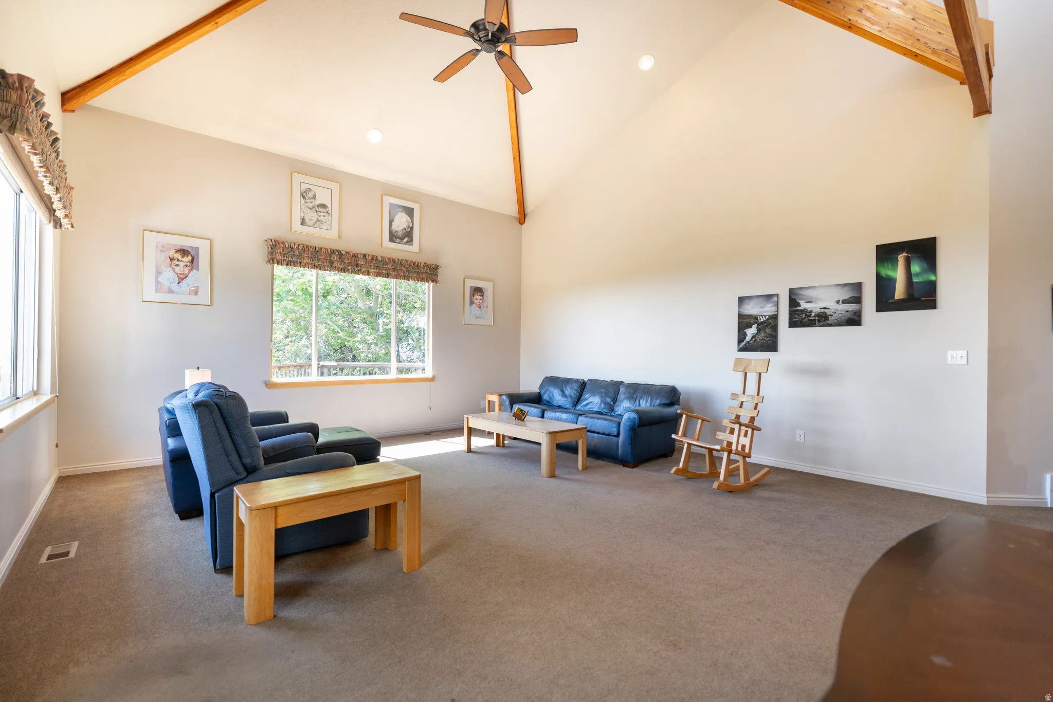 Vaulted ceilings with exposed wood beams, ceiling fan with light fixture, recessed lighting, expansive windows, and wall-to-wall carpeting