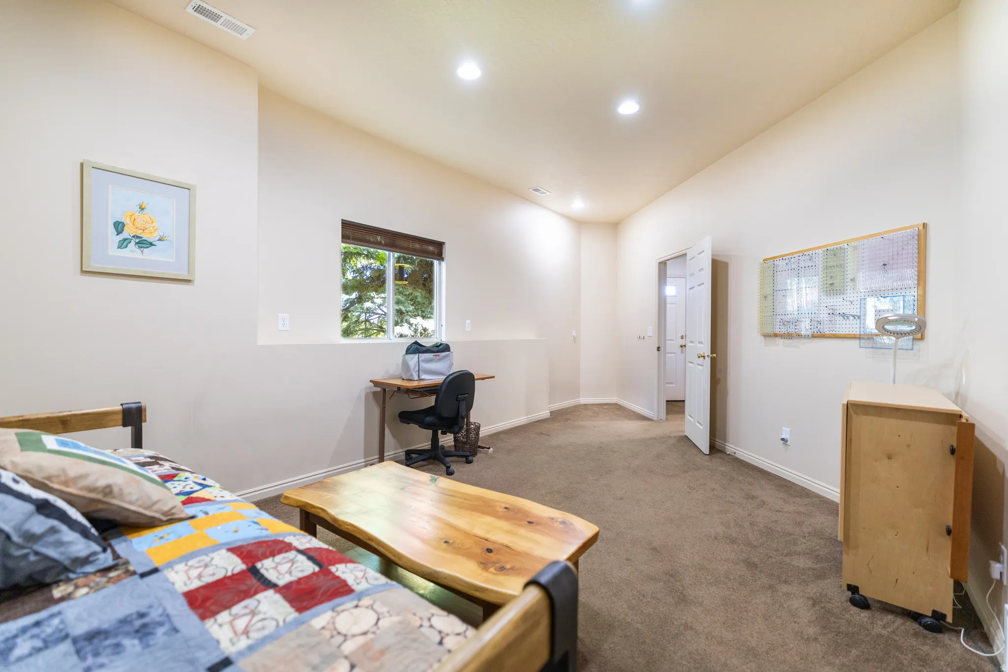 Carpeted room with recessed lighting and a window featuring a brown blind