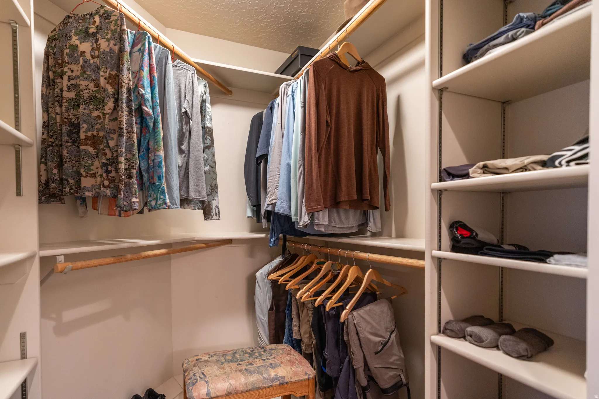 Walk-in closet featuring built-in shelving, multiple hanging rods, and perimeter storage