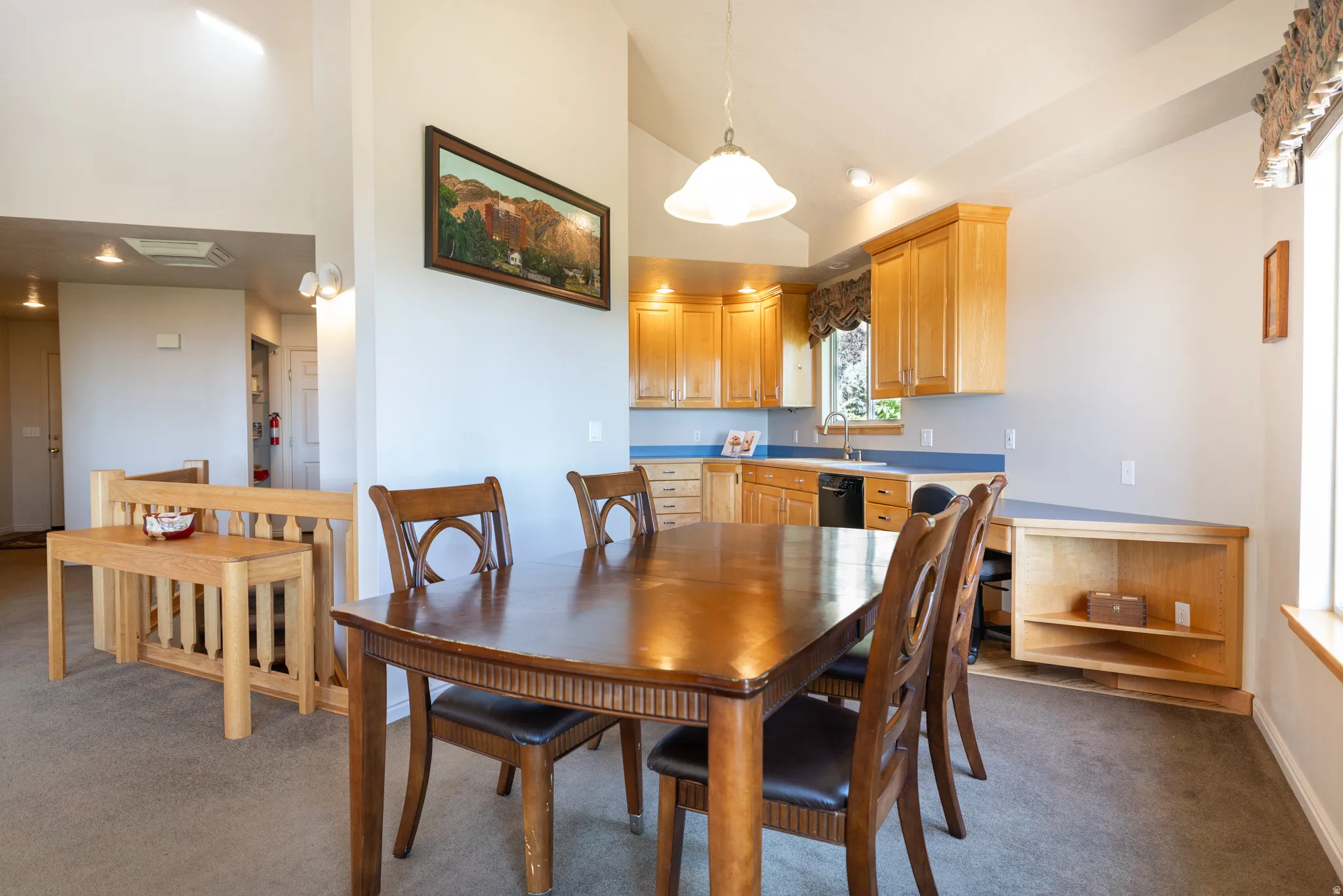Kitchen featuring natural wood cabinetry, blue countertops, and a stainless steel sink