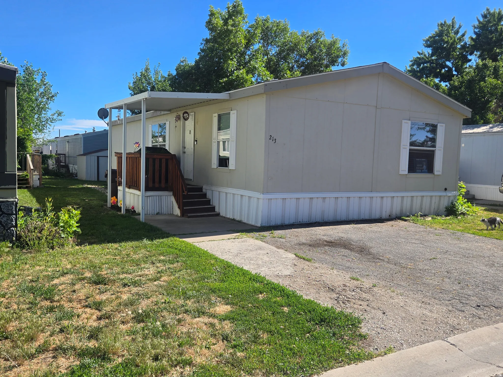 Manufactured home with light-colored siding and a covered entry porch