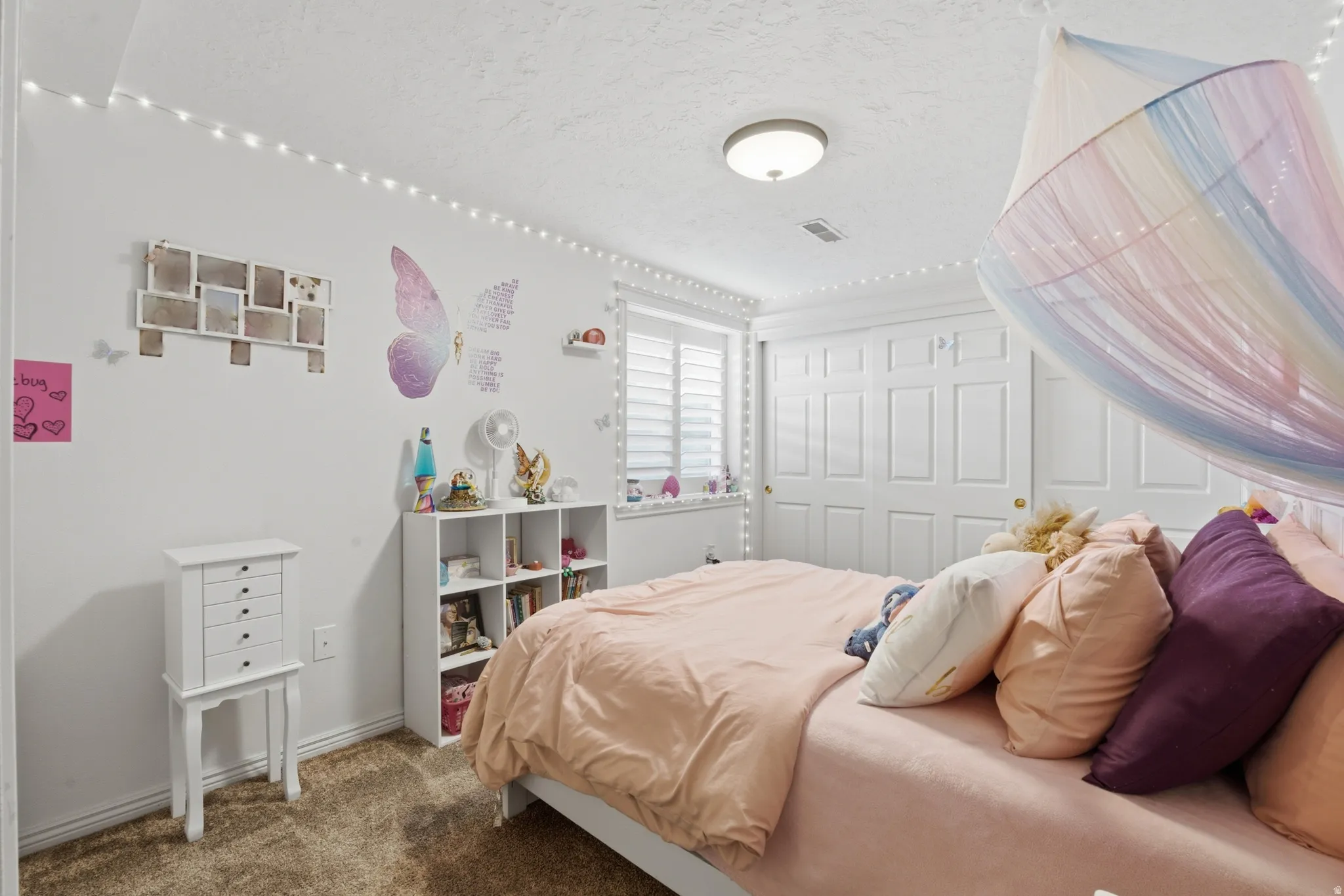 Carpeted room featuring a window with horizontal blinds, built-in closet with bifold doors, and a flush-mount ceiling light