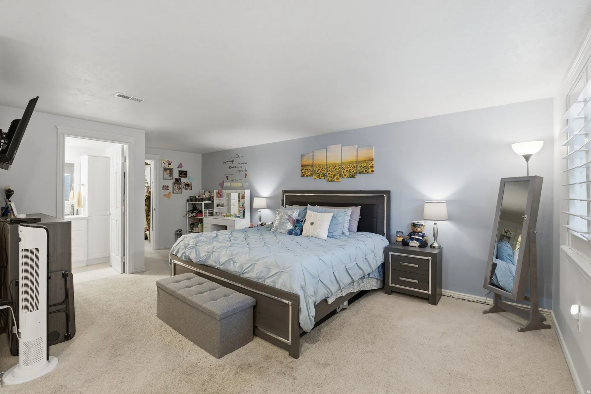 Spacious room featuring neutral carpeting and a light blue accent wall