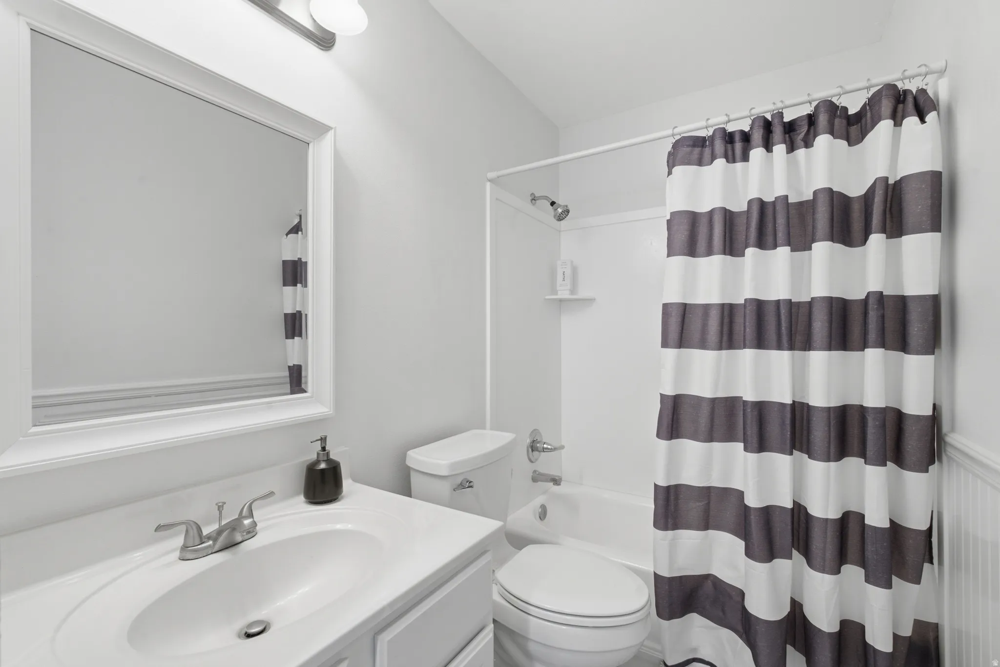 Bathroom featuring a vanity with an integrated sink, a framed mirror, and a full bathtub with a shower