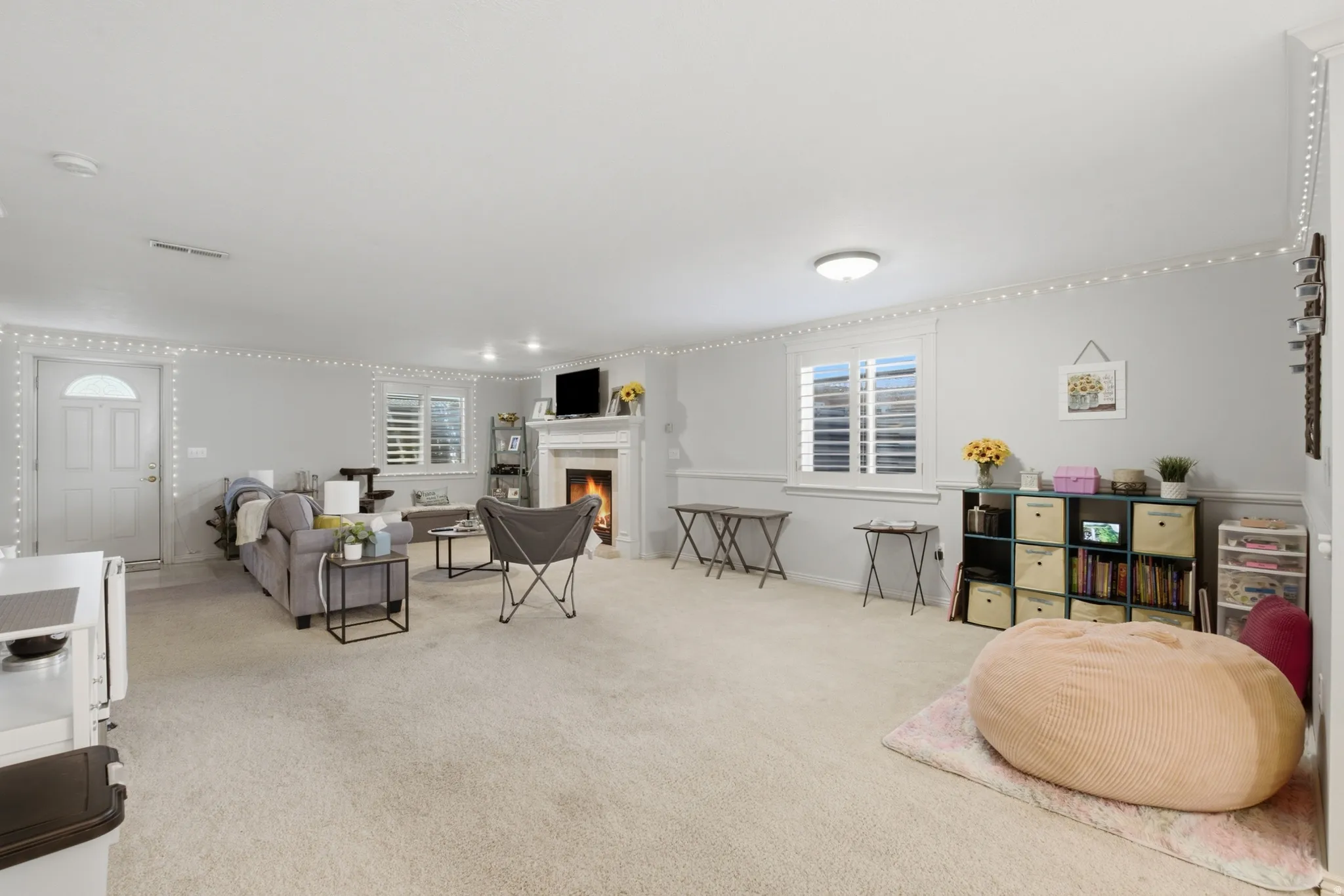 Spacious living area featuring light-toned carpeting and neutral wall tones