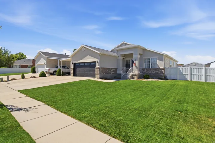 Ranch-style exterior featuring a covered entry, stone veneer accents, and a two-car garage with a dark panel door