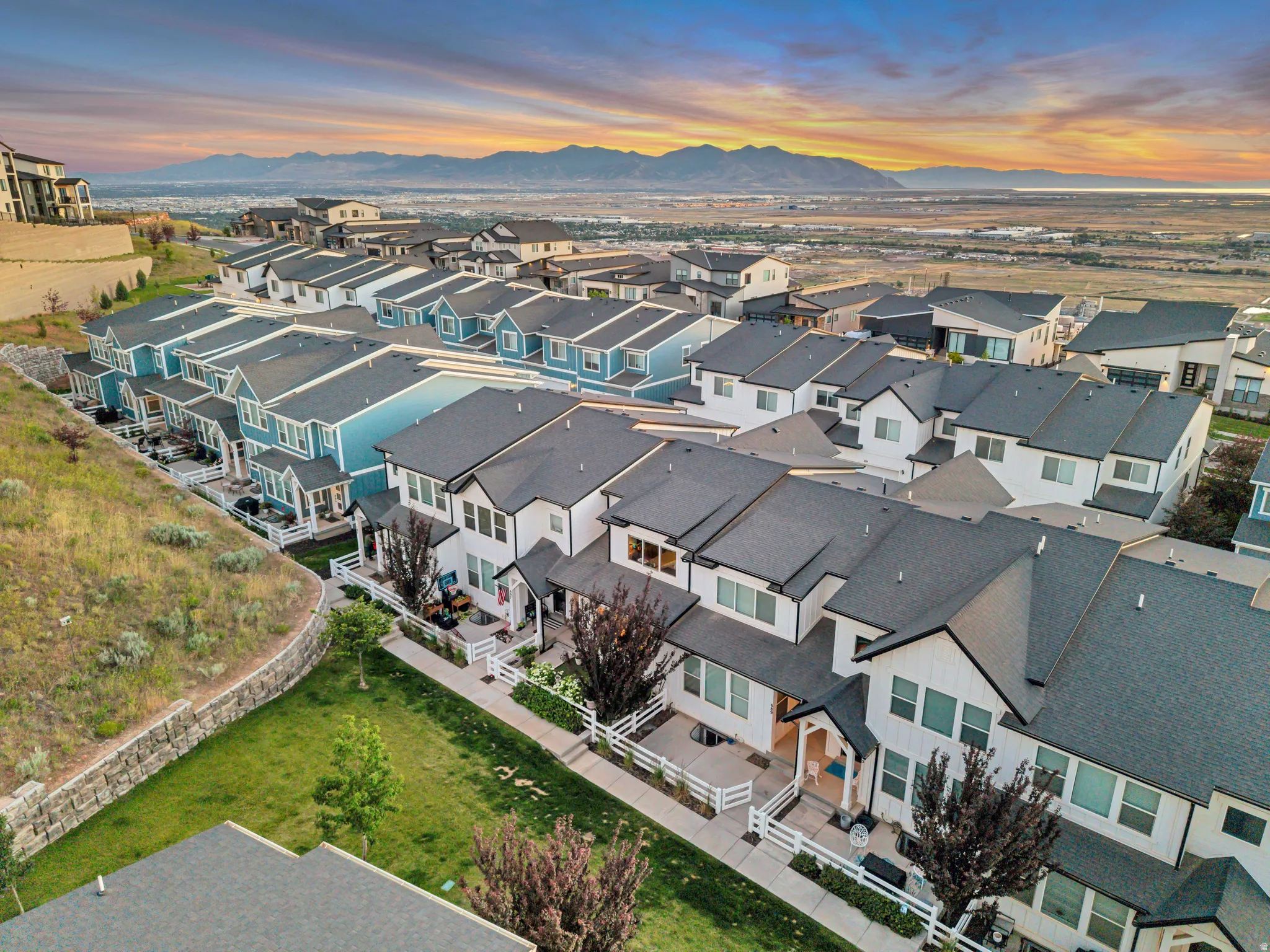 Modern townhome community featuring contemporary architectural styles, dark shingle roofing, and contrasting light-colored exteriors