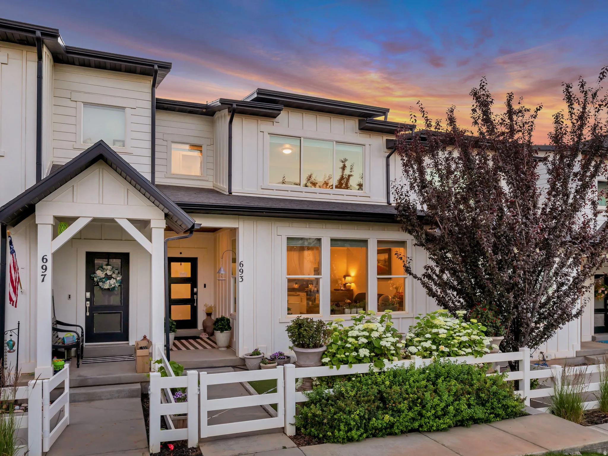 Modern farmhouse-style exterior featuring white siding and black trim