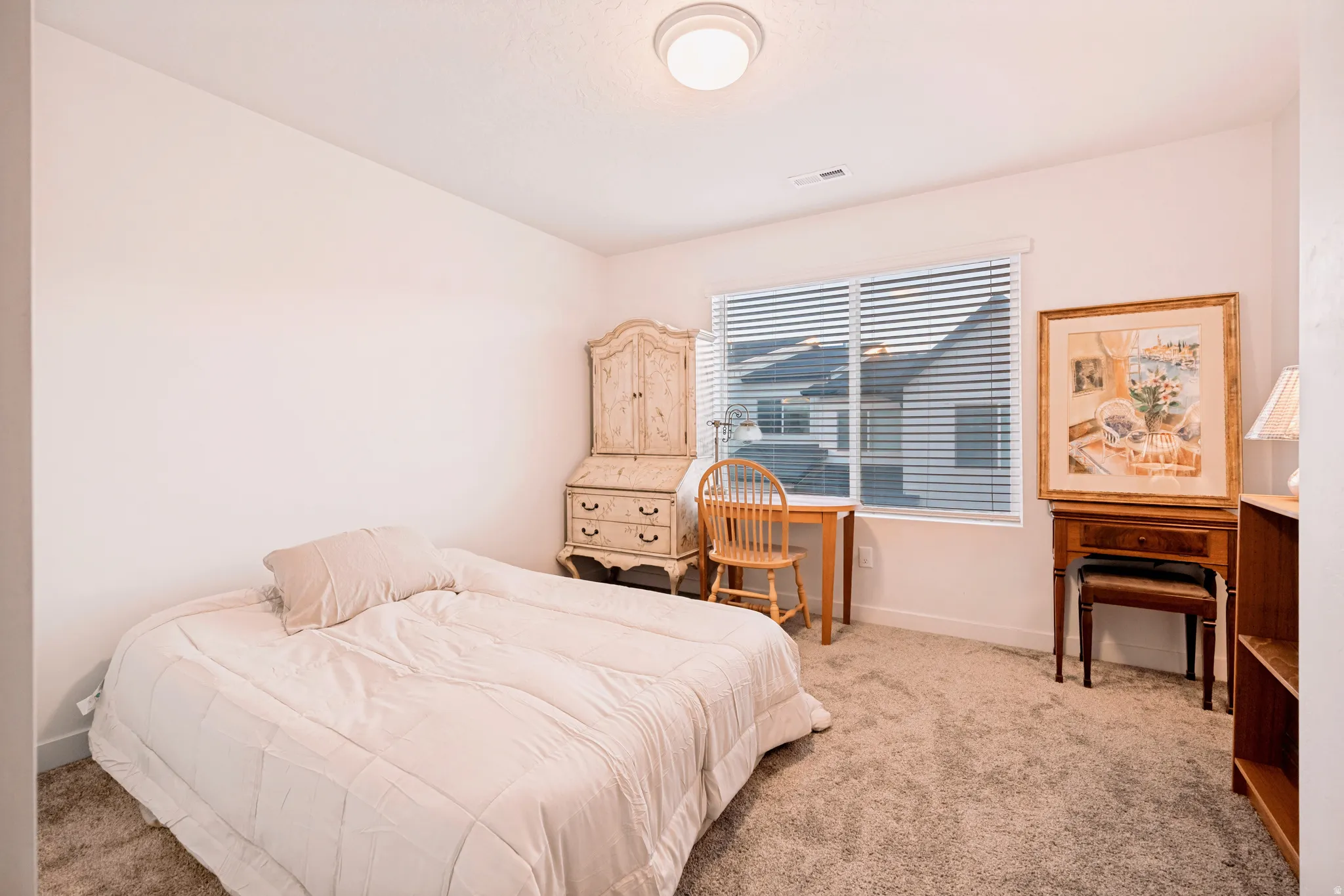 Carpeted room featuring a single window with blinds, a built-in light fixture, and light-colored walls