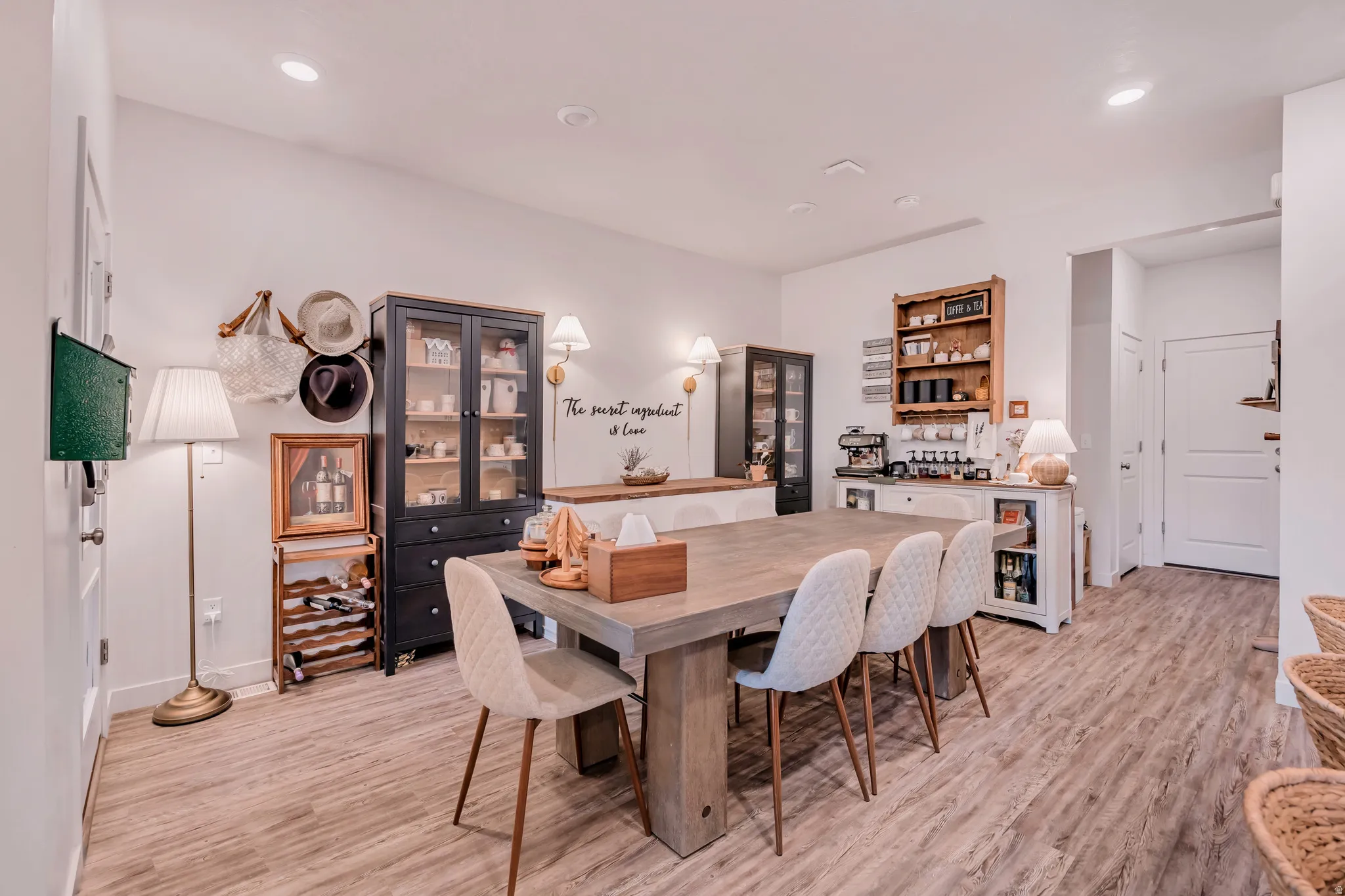 Open-concept dining area featuring wood-finish flooring, recessed lighting, and a built-in beverage station with open shelving