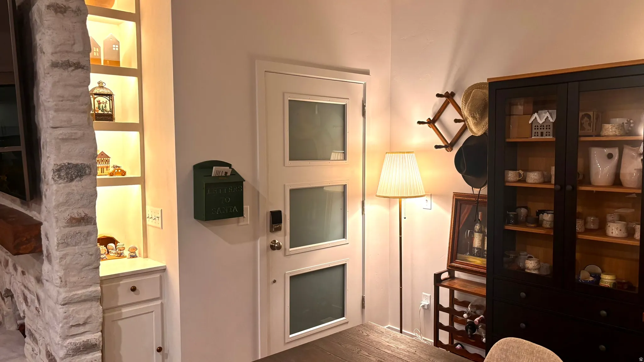 White paneled door with three frosted glass panels, featuring a satin nickel doorknob and smart lock