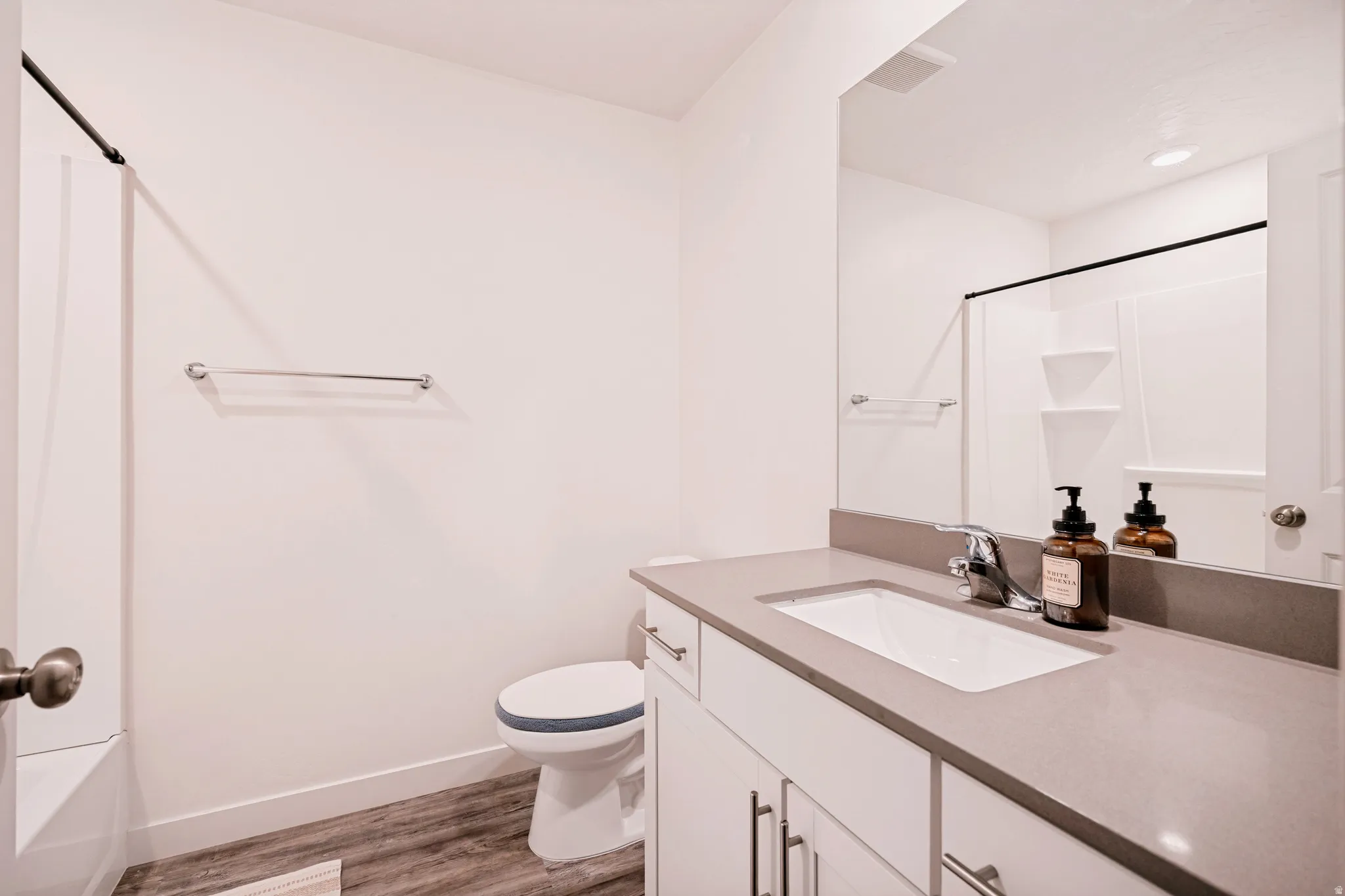 Bathroom featuring a vanity with an integrated sink, a gray countertop, and white cabinetry