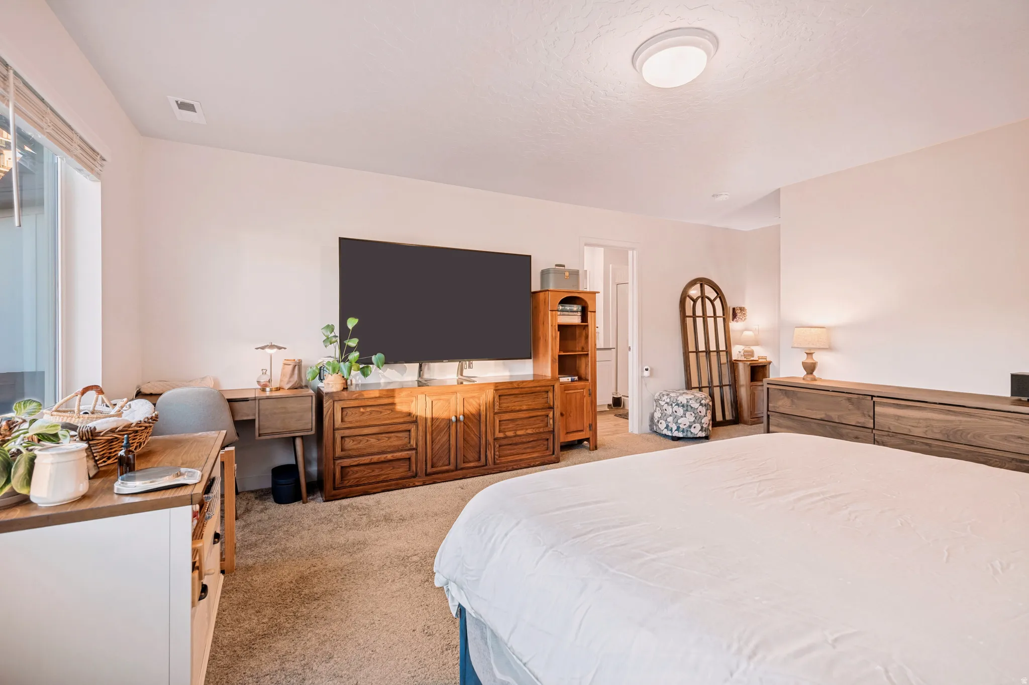 Carpeted interior room featuring light-toned walls, a large window with blinds, and recessed lighting