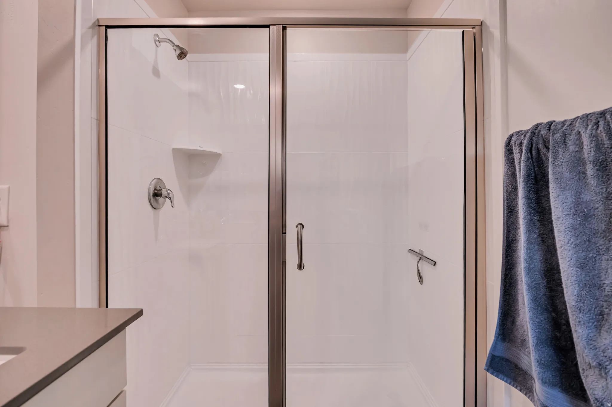 Shower enclosure featuring clear glass panels with bronze-finish framing