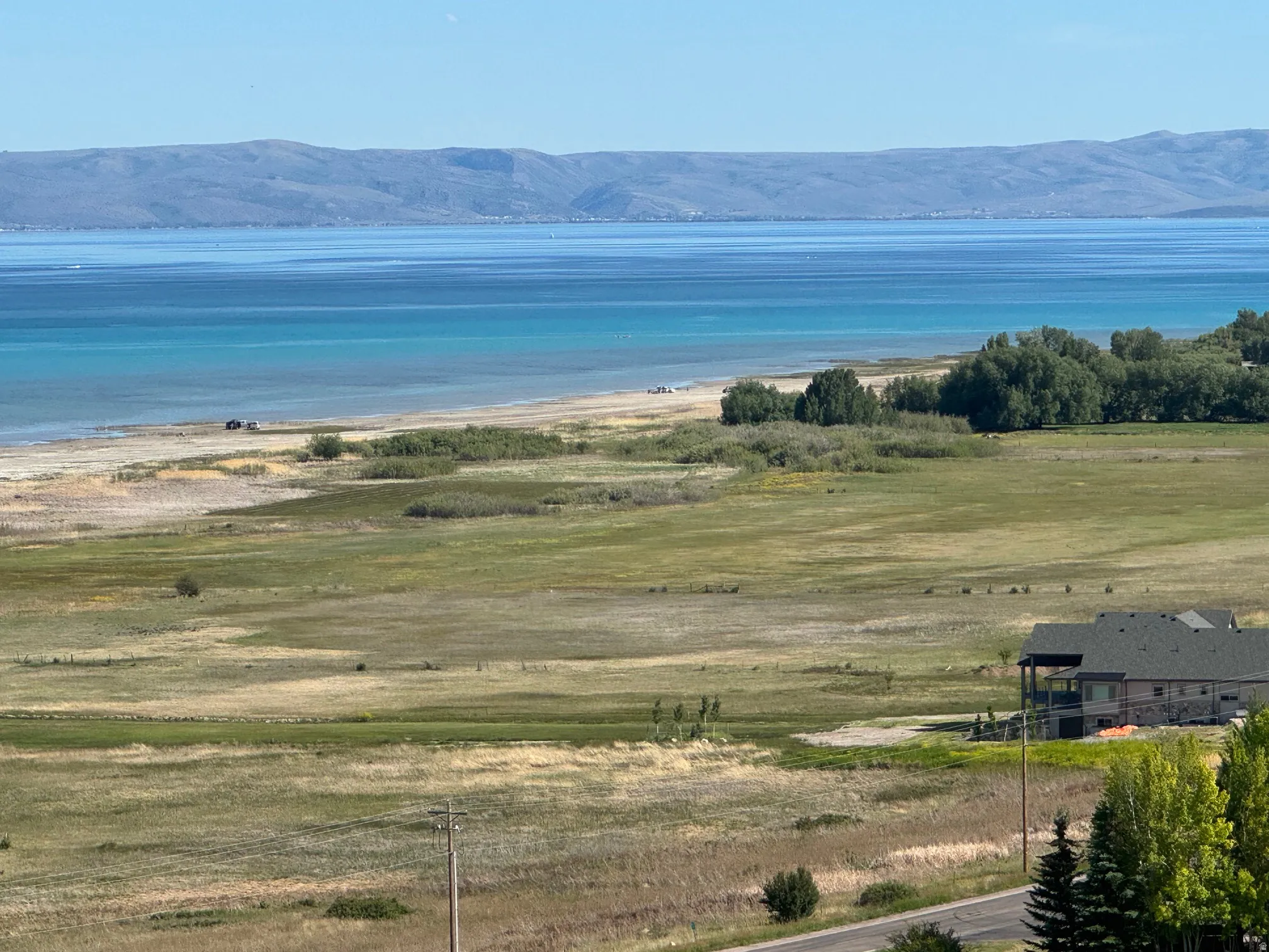Expansive water frontage with a sandy beach and mountainous backdrop