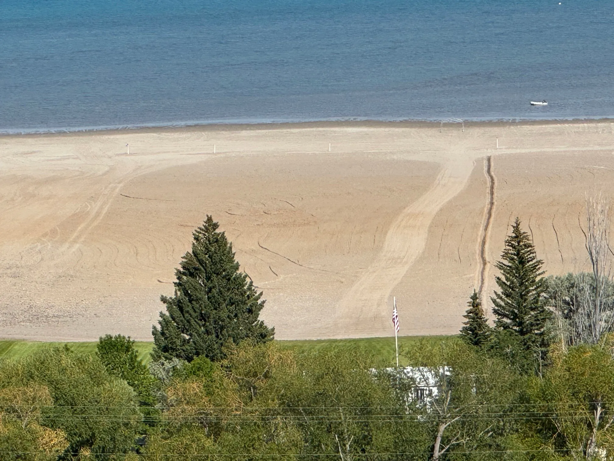 Expansive sand beach bordering calm blue water