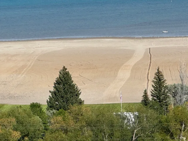 Expansive sand beach bordering calm blue water