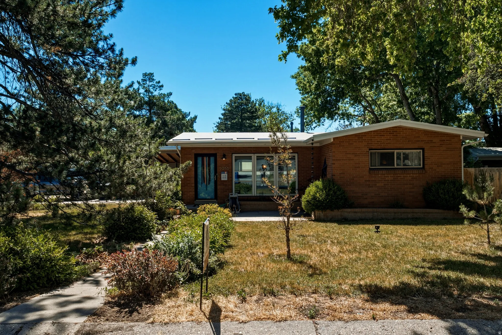 Brick ranch-style exterior with a contrasting blue entry door