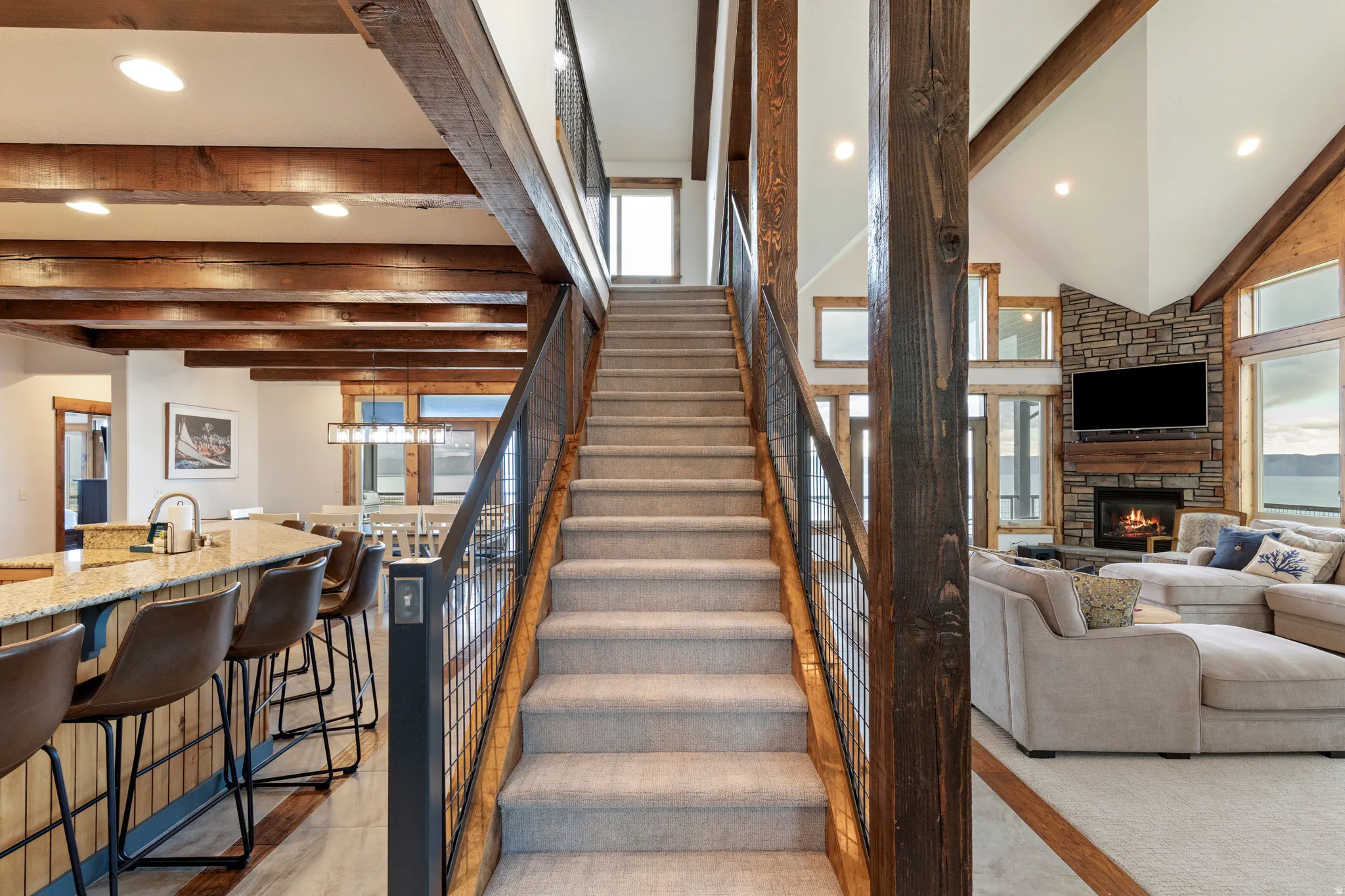Grand staircase with metal railing and wood posts