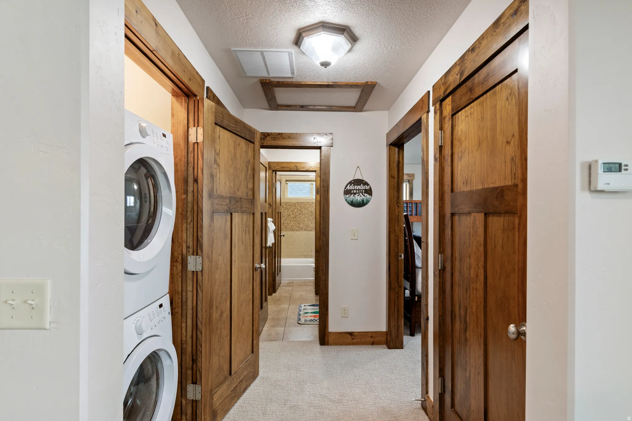 Hallway featuring wood-finish doors and trim, carpeted flooring, and a recessed lighting fixture