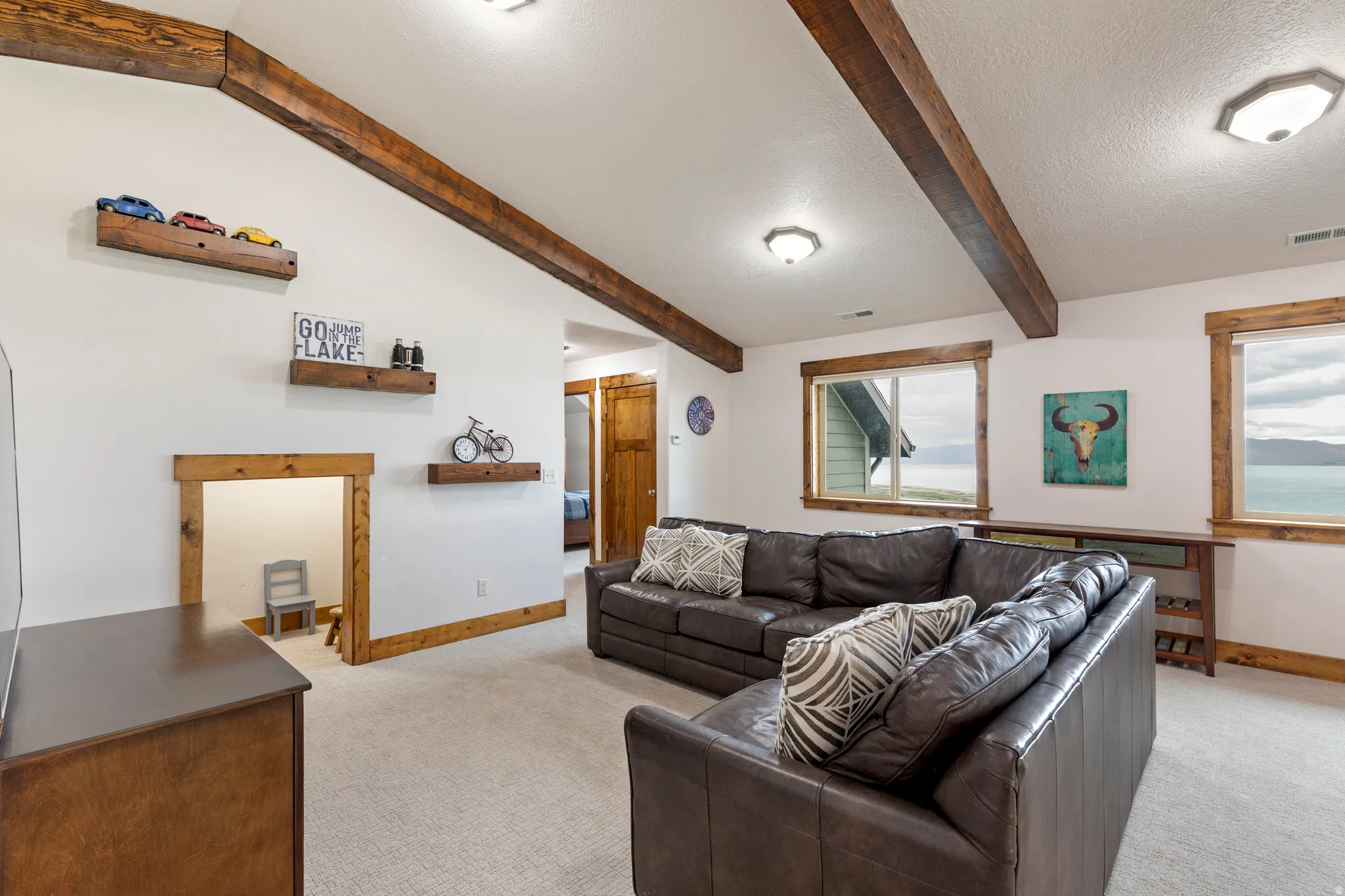 Living area featuring exposed wood beams and recessed lighting