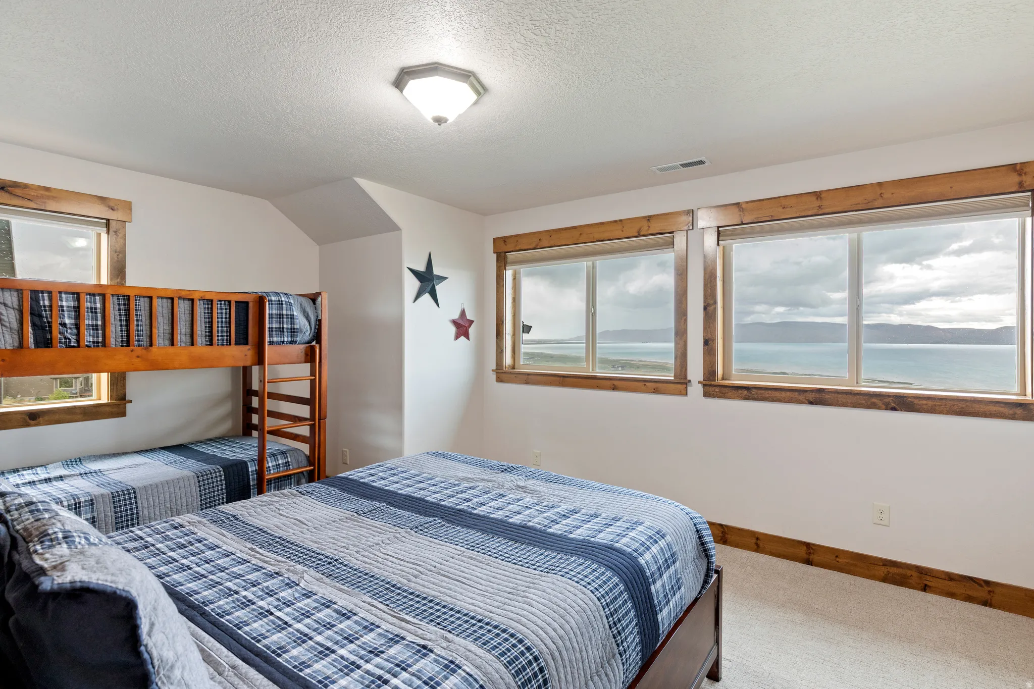 Bedroom featuring multiple windows with wood-finish trim, offering expansive water scenery