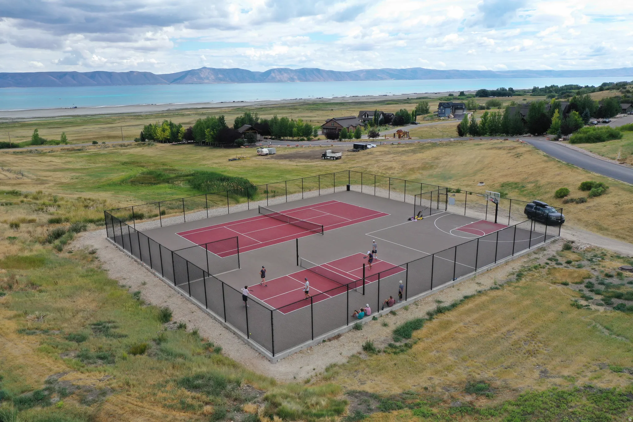 Multi-sport court complex featuring two full tennis courts, two pickleball courts, and a half-basketball court