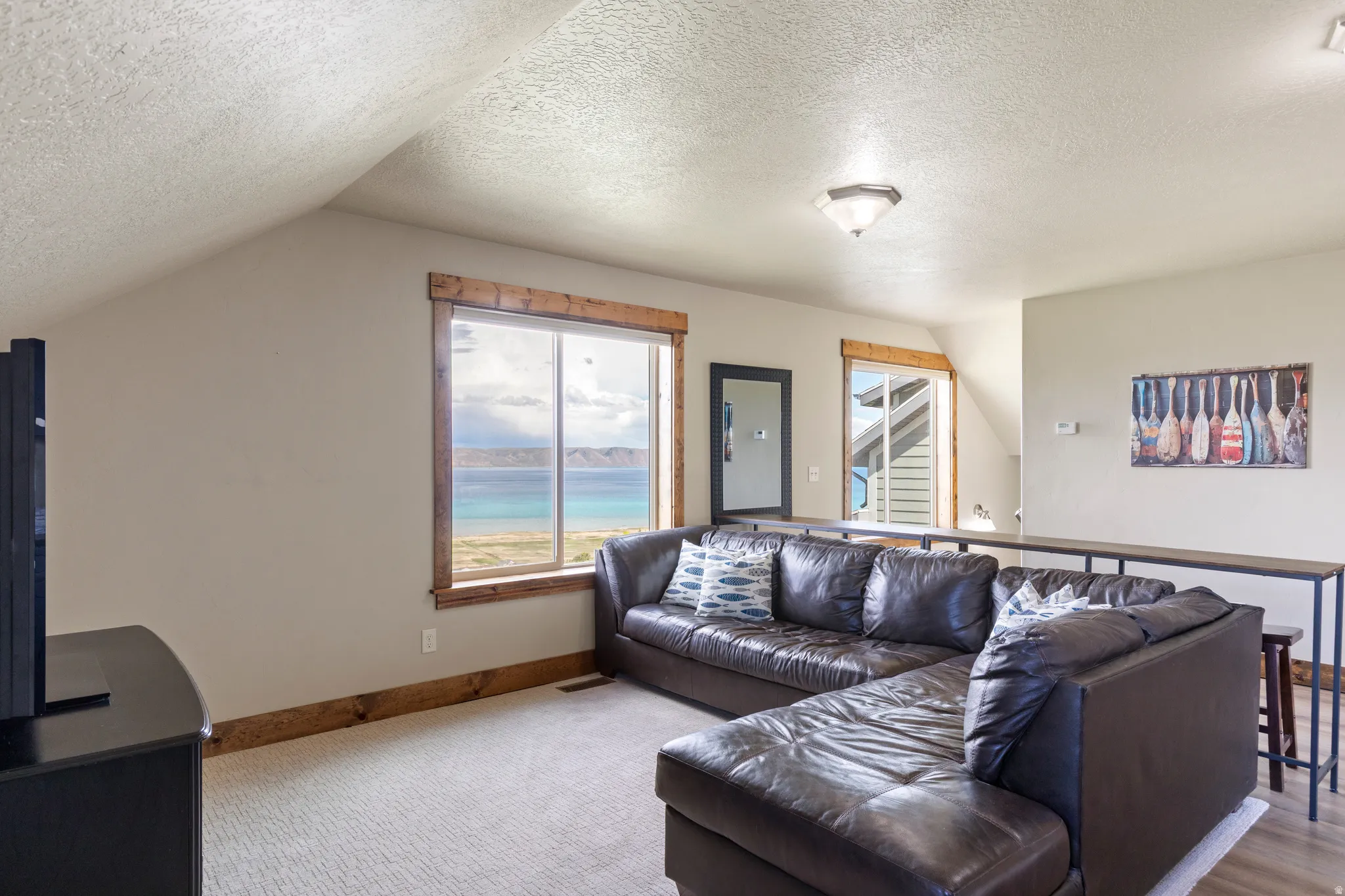 Bright room featuring a large window with direct water scenery