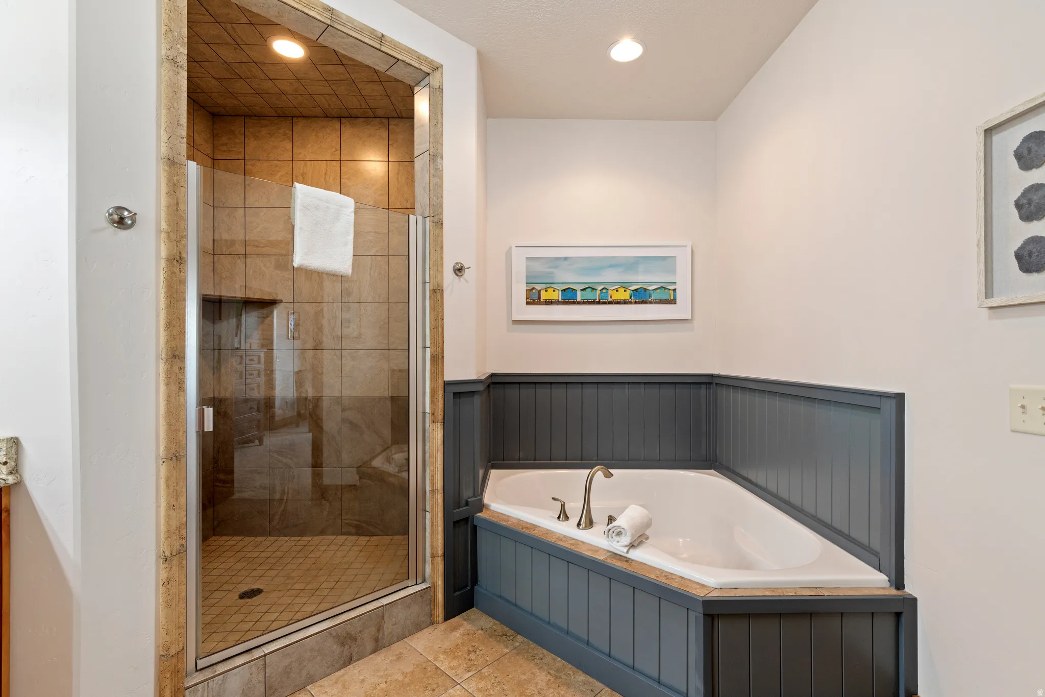 Walk-in shower with clear glass enclosure and tiled interior, featuring an integrated shower niche and recessed lighting